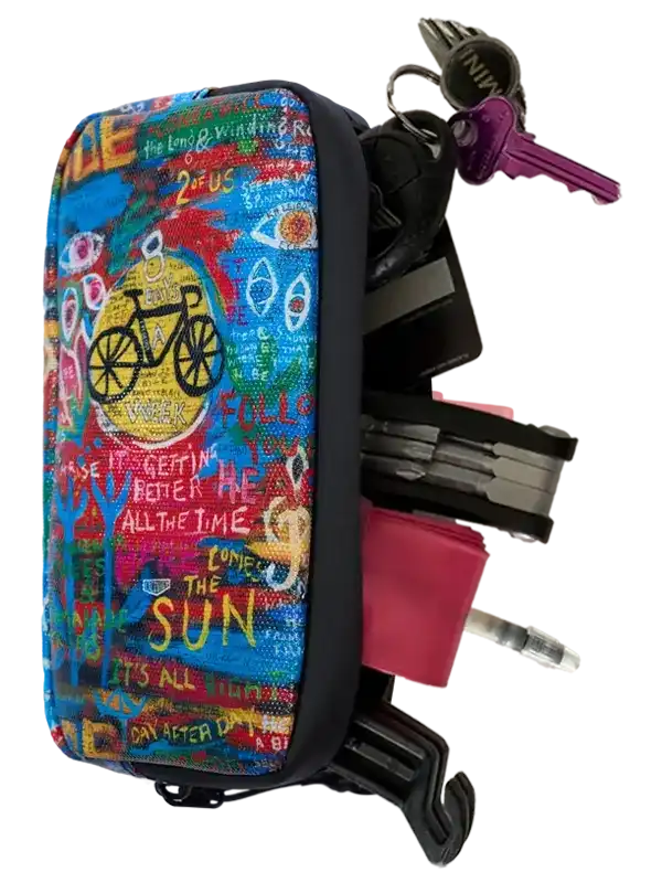 Colorful cycling-themed key organizer with bike graphics and motivational text, holding keys and tools