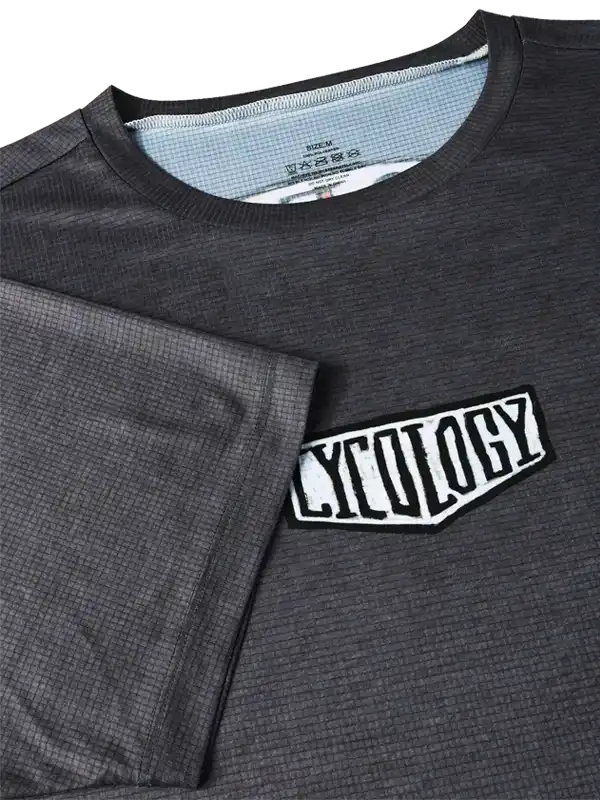 Men's dark grey cycling jersey with textured fabric and bold 'CYCOLOGY' chest logo, ideal for performance rides.