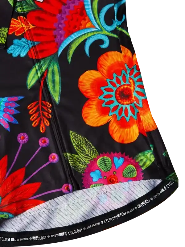 Vibrant floral cycling jersey with bold orange, red, and teal flowers on black fabric, featuring mesh hem and brand tag.