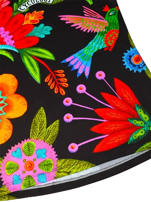 Vibrant floral and hummingbird print on black cycling shorts, featuring colorful nature-inspired design.