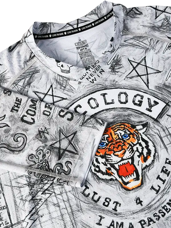 Close-up of a V neck MTB shirt with graphic designs and text, including a tiger and star symbols.