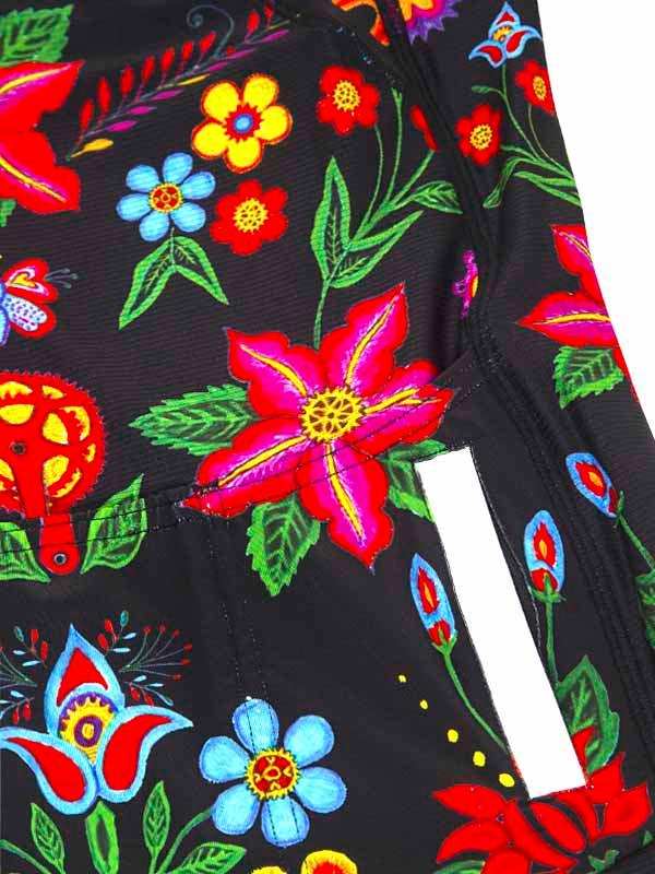 Vibrant floral cycling shorts with bold red, blue, and yellow flowers on black fabric, featuring reflective strip.