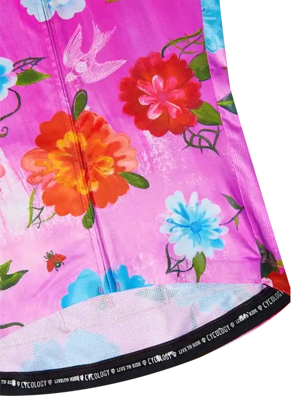 Vibrant floral cycling jersey with pink background, colorful flowers, birds, and 'Cycology' waistband detail
