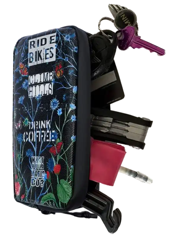 Cycling key organizer with floral design, holding keys, tools, and coffee pod for bike rides