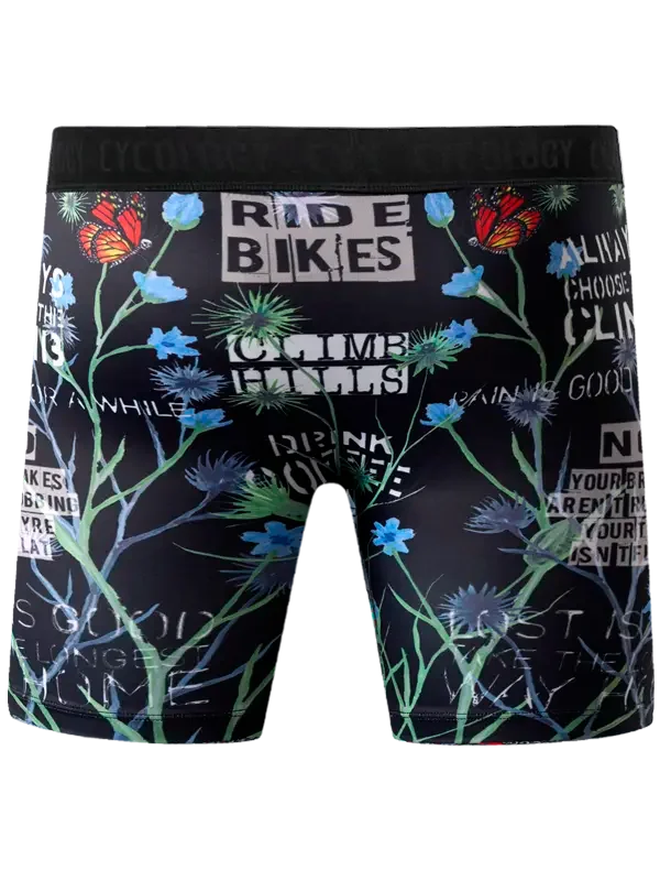 Men's cycling shorts with floral print, butterflies, and motivational text like 'RIDE BIKES' on black fabric