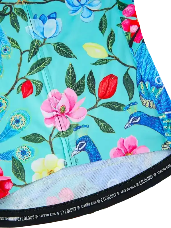 Women's cycling jersey with vibrant peacock and floral print on teal background, featuring mesh hem detail.