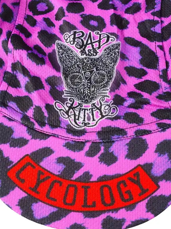 Pink leopard print cycling jersey with 'Bad Ass Kitty' cat graphic and red 'Cycology' banner