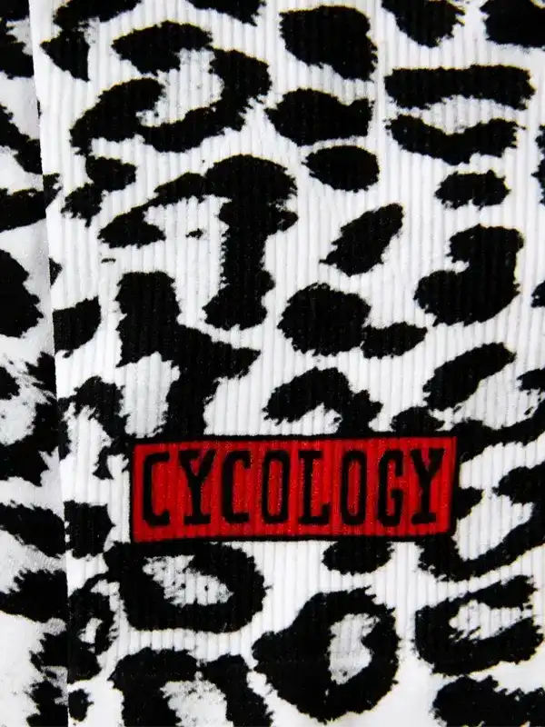Cycology cycling sock with bold black and white leopard print and red logo patch