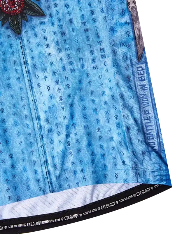 Blue cycling jersey with rune pattern, rose graphic, and 'No Battle Is Won In Bed' text on sleeve