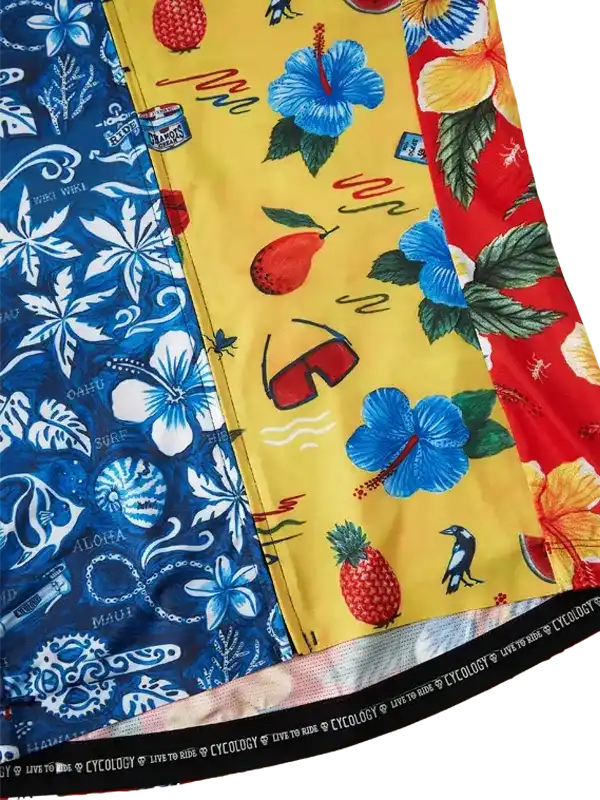 Vibrant tropical print cycling jersey with hibiscus, pineapple, and beach motifs in blue, yellow, red panels