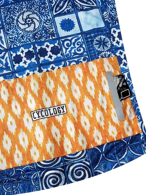 Cycology cycling shorts with blue tile and orange ikat pattern, featuring brand label and reflective strip