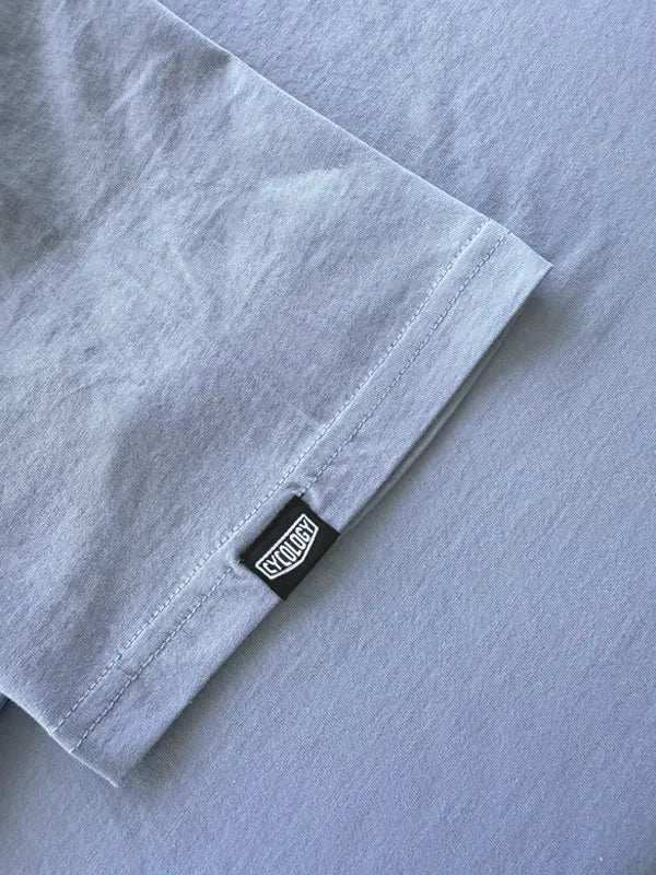 Light gray cycling t-shirt sleeve with black brand tag, soft fabric detail for men's and women's bike wear