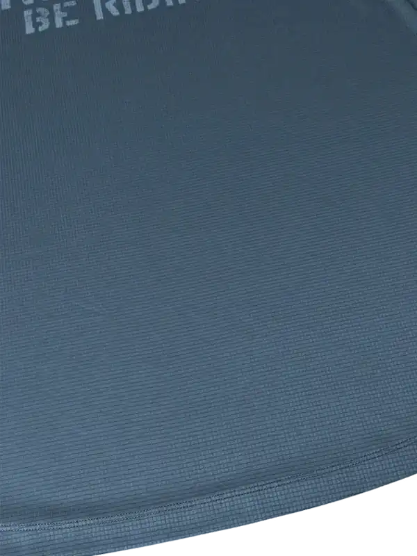 Close-up of blue cycling jersey fabric with 'BE RIDE' text, showcasing breathable texture for men's and women's bike wear