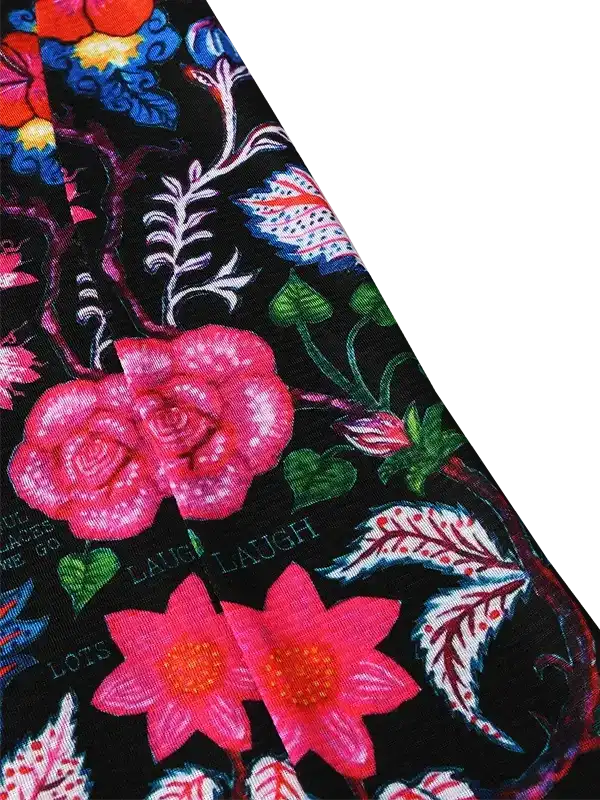 Vibrant floral print cycling jersey with pink roses, green leaves, and 'LAUGH' text on black fabric