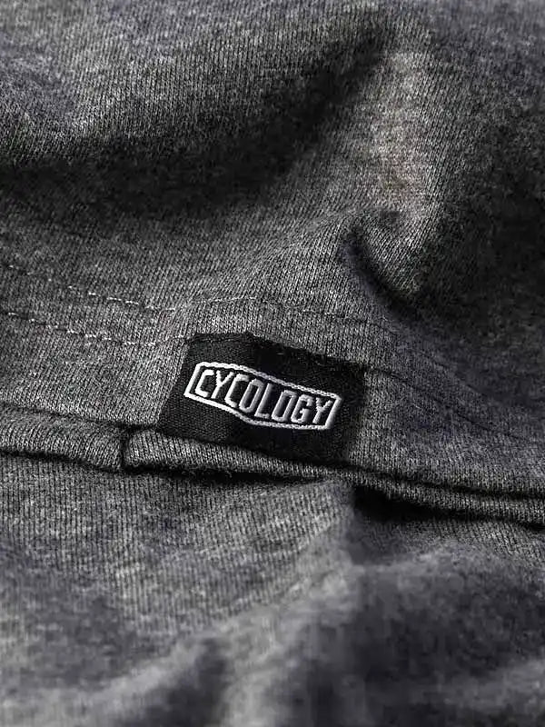 Cycology brand tag on dark grey cycling apparel fabric, showcasing quality stitching and design detail.