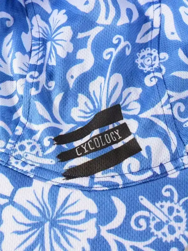 Blue floral cycling jersey with white hibiscus pattern and black Cycology logo tag