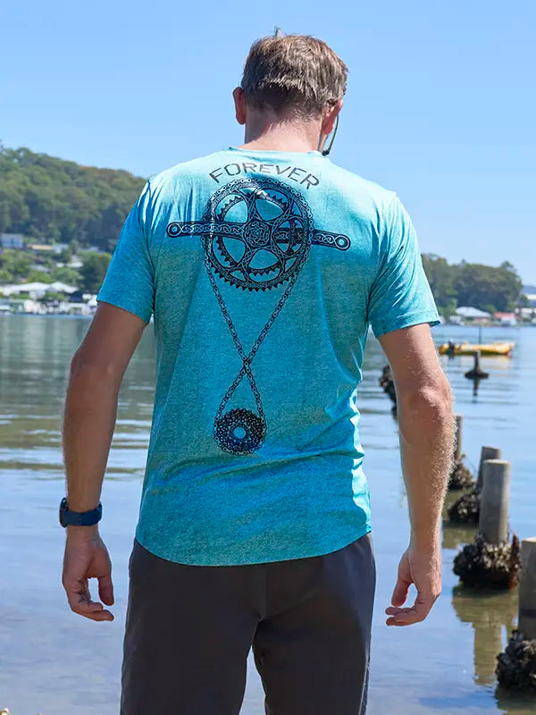 Person wearing a teal green technical t-shirt with a design and text on the back