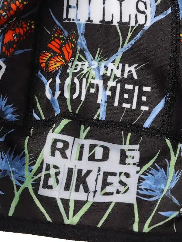 Cycling jersey with butterfly print, 'Drink Coffee Ride Bikes' text, and floral design