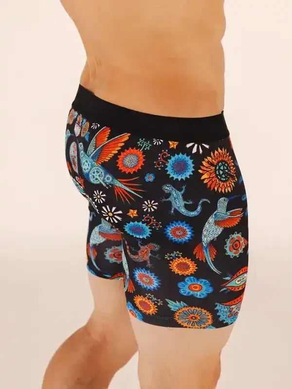 Men's cycling shorts with vibrant bird and floral pattern on black fabric, designed for comfort and style.