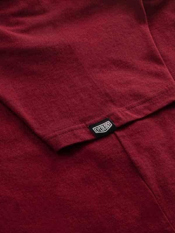 Cycology branded tag on deep red cycling apparel fabric, showcasing quality stitching and design detail