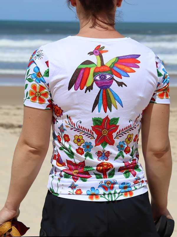 Women's cycling jersey with colorful floral and bird print, beach backdrop