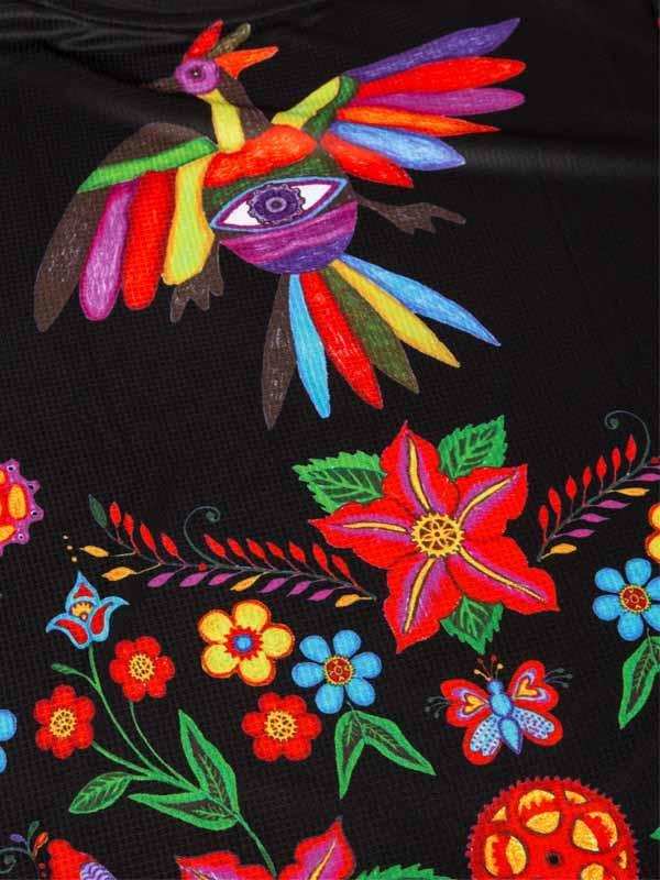 Vibrant floral and bird print on black cycling jersey fabric, featuring colorful flowers and a rainbow-winged bird design.