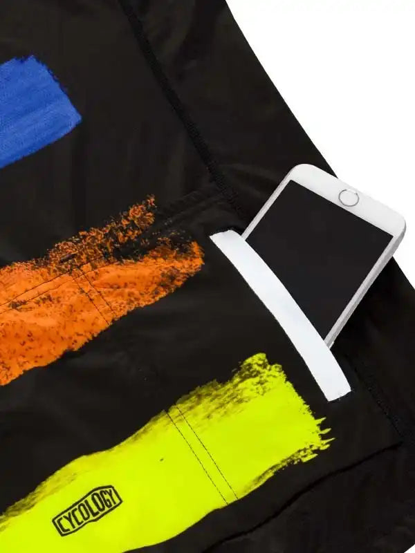 Black cycling jersey with bold brushstroke graphics in blue, orange, and neon yellow, featuring a phone pocket and Cycology logo.