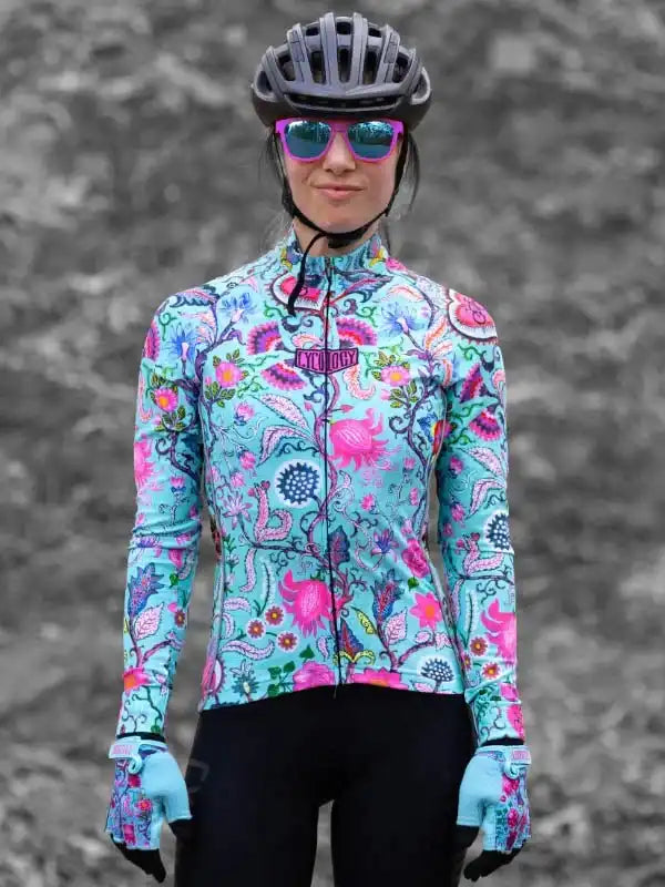Woman in colorful floral cycling jersey, helmet, and sunglasses, ready for a ride.
