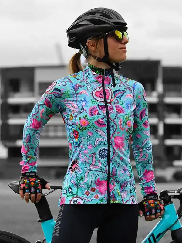 Woman in vibrant floral cycling jersey, helmet, and gloves, ready to ride her bike.