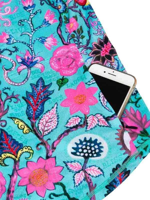 Vibrant floral cycling jersey pocket holding smartphone, featuring pink flowers and teal background