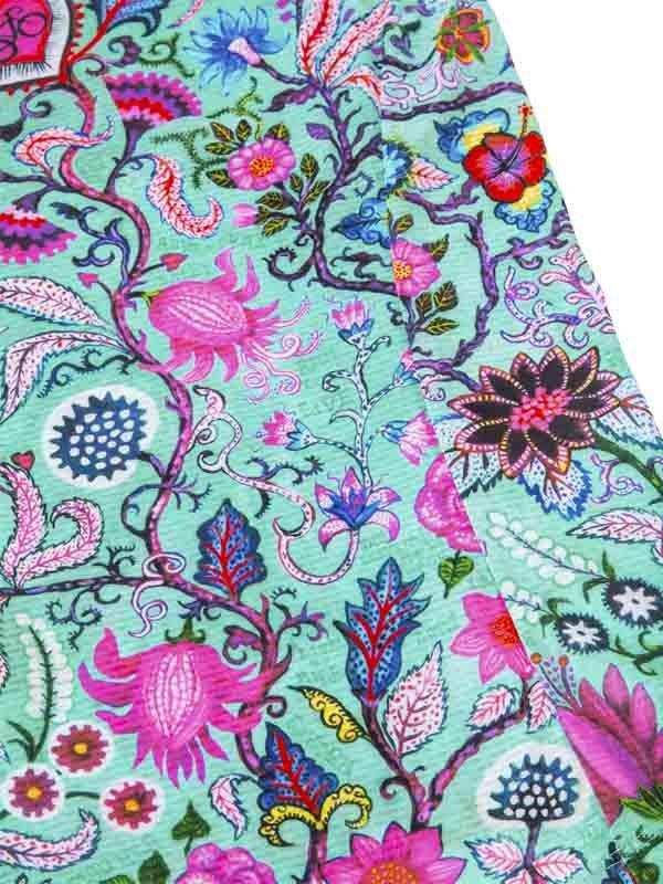 Vibrant floral pattern on cycling apparel fabric, featuring pink, blue, and teal botanical designs for women's and men's wear.