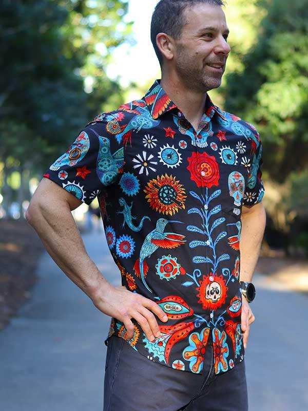 Man wearing vibrant floral and skull print short-sleeve cycling shirt outdoors