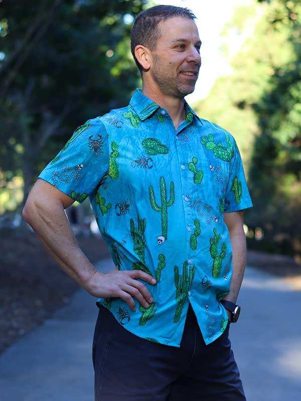 Man wearing blue cactus-print short sleeve shirt outdoors, casual cycling apparel