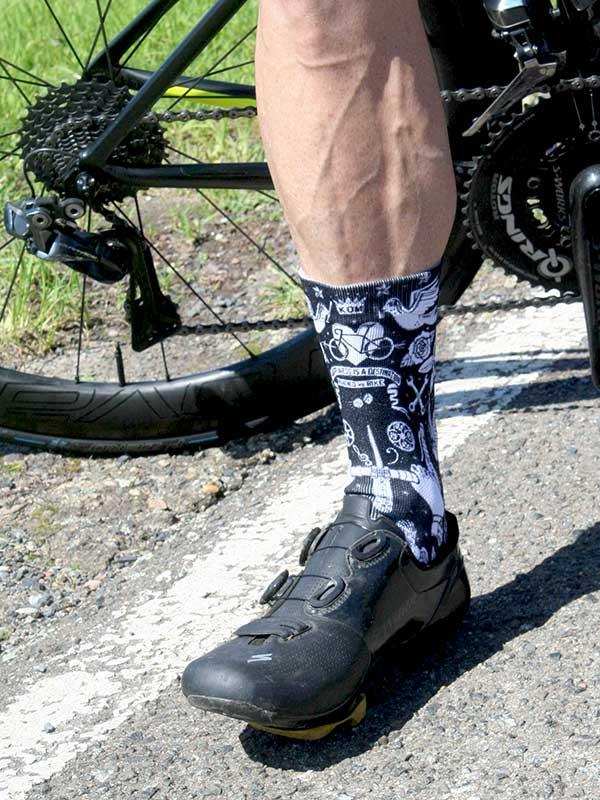 Cycling socks with bike graphics worn with black cycling shoes and road bike