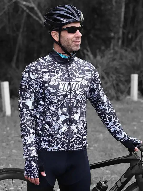 Man in patterned cycling jersey and helmet, standing with road bike outdoors