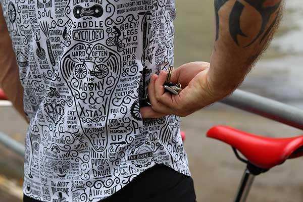 Cycling jersey with bold black-and-white graphic print, worn by cyclist near red bike saddle