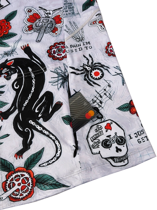 Close-up of a fabric with tattoo-style designs including a panther, skull, and text with back zip pocket