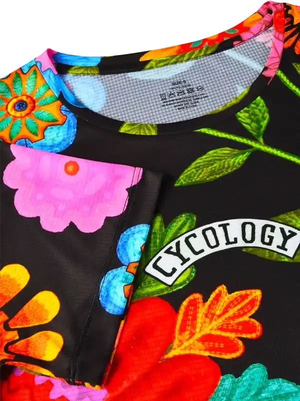 Vibrant floral cycling jersey with bold colors and 'CYCOLOGY' logo, designed for performance and style.