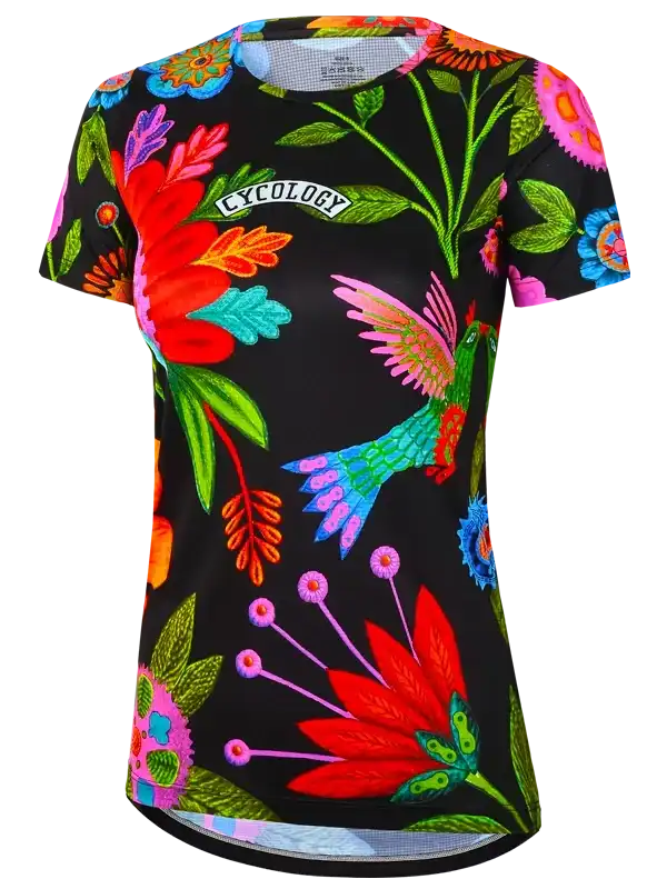 Women's cycling jersey with vibrant floral and hummingbird print on black background, featuring 'CYCOLOGY' logo.