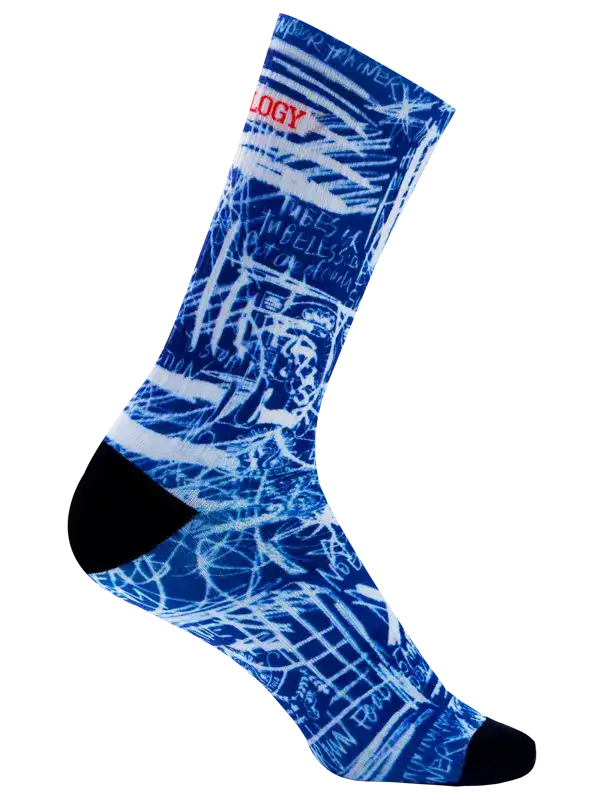 A single crew cycling sock with a blue and white abstract graffiti-style graphic print, featuring the word 'CYCOLOGY' in red text across the upper calf and a solid black toe section, shown on a plain white background.