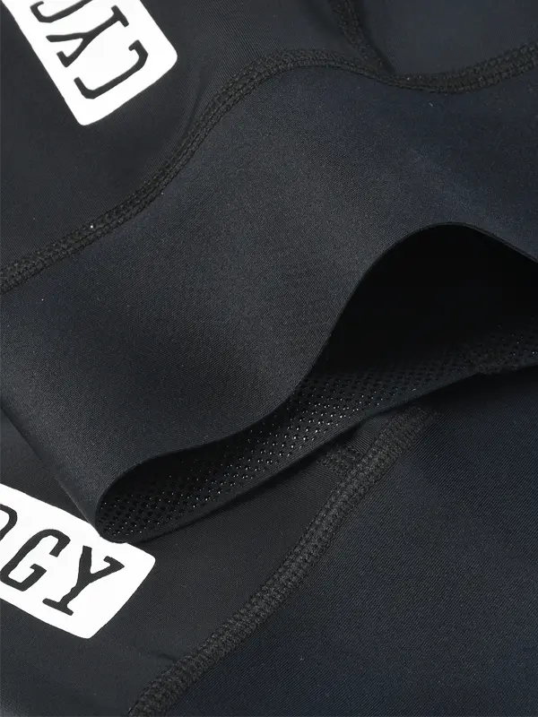 Close-up detail shot of black athletic cycling bibs showing the fabric texture, grip inside leg cuff 