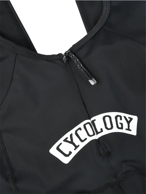 Close-up of a black quick pee cycling bibs zipper at the rear with a white arched 'CYCOLOGY' logo patch on the back, 