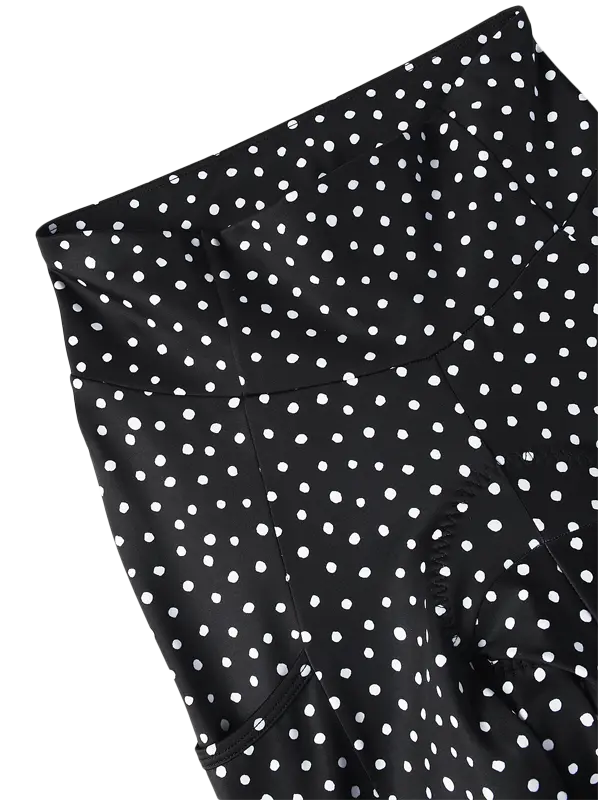 Black fabric with a white polka dot pattern, shown in a close-up detail shot against a white background.