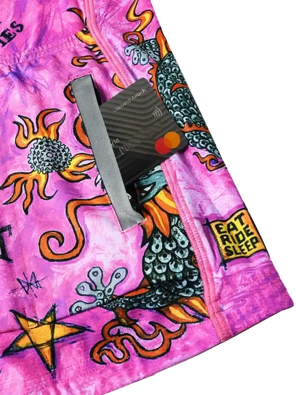 Vibrant pink cycling shorts with dragon, sun, and 'Eat Ride Sleep' graphic design