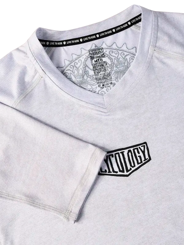 Close-up of a grey V Neck MTB Jersey  with a logo on the chest