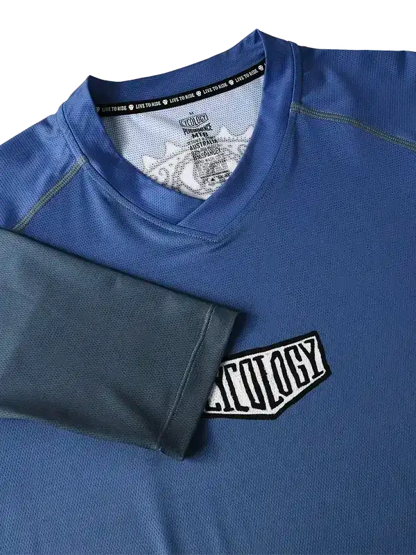 Blue men's cycling jersey with 'Cycology' patch and 'Live to Ride' tag, performance fabric design