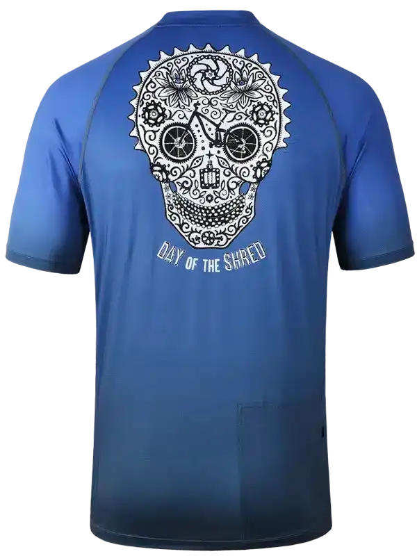 Blue cycling jersey with sugar skull graphic, 'Day of the Shred' text, and bike wheel eyes design
