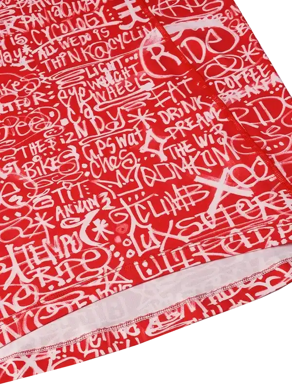 Red cycling jersey with white graffiti-style text print, featuring cycling phrases and bold design