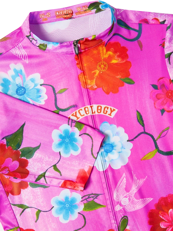 Pink cycling jersey with colorful floral designs and 'cycology' branding.