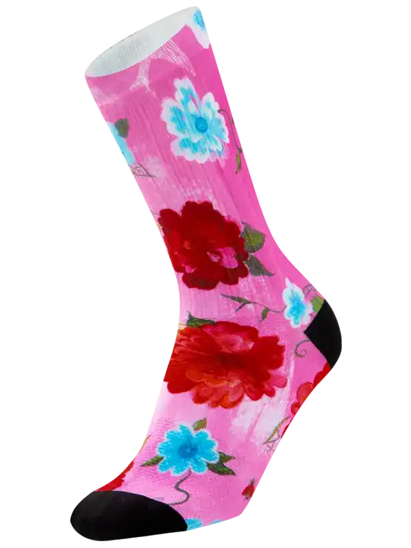 A single pink crew cycling sock with a bold floral print featuring large red and light blue flowers, green leaves, and black toe and heel sections, shown on a plain white background.